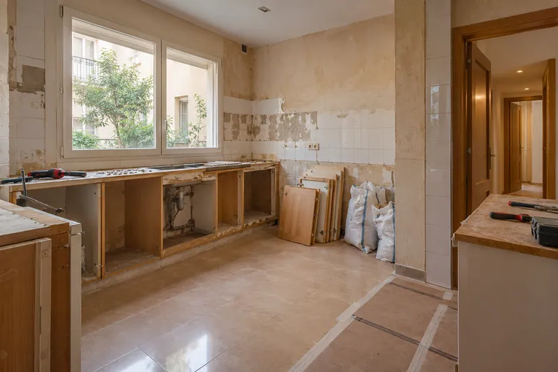 Visualización conceptual IA: Retirada de muebles y revestimientos al comienzo de una reforma de cocina.